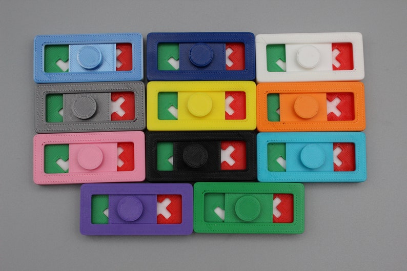 May include: Twelve colorful plastic fidget toys with a check mark, a circle, and an X on each. The toys are arranged in four rows of three.