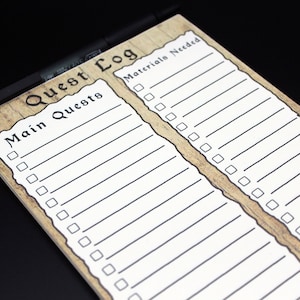 May include: A brown and white notepad with a woodgrain design. The notepad has two sections, one labeled "Main Quests" and the other labeled "Materials Needed". Each section has a checklist with blank lines for writing.