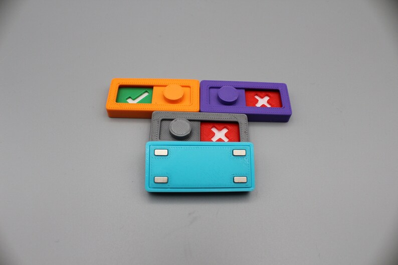 May include: Four small plastic toggle switches with different colored bases and symbols. The switches are orange, purple, gray, and blue. The symbols are a green checkmark, a red X, a white X, and a blank space.