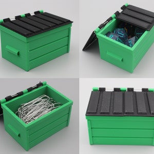 May include: A green and black miniature dumpster with a hinged lid. The lid is open and the inside is empty. The dumpster is about 4 inches long and 3 inches wide.