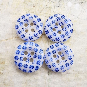 May include: A white ceramic mug with a black handle and the text "But First, Coffee" in a black, handwritten-style font. The mug is on a white surface.