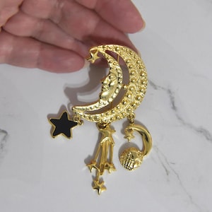 Vintage Gold Toned Celestial Crescent Moon Brooch Decorated with Dangles, a Black Enamel Star, Shooting stars and a Moon and Earth.