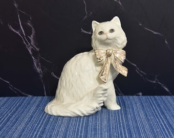 Figura de gato vintage Lenox Classic Cat sentado, de pelo largo, color blanco marfil, con detalles en oro de 24 quilates en el lazo.