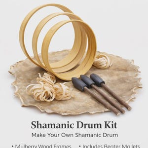 May include: A Shamanic Drum Kit with mulberry wood frames, beater mallets, and other materials. The kit includes three wooden hoops, bundles of wood shavings, and three drum mallets with dark grey heads. The text reads "Shamanic Drum Kit".