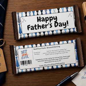 Può includere: Due confezioni di barrette di cioccolato con messaggi per la festa del papà. Una dice "Happy Father's Day!" e l'altra "Best Dad Ever". Le confezioni hanno un motivo a cravatta blu. Sono visibili anche una confezione regalo, una cravatta e un biglietto con "You're the Best!"