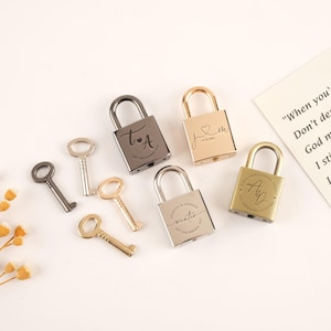 Peut inclure: Plusieurs cadenas personnalisés en argent, or et gris canon de fusil, avec des clés assorties. Les cadenas présentent des initiales, des dates et des noms gravés, parfaits pour les mariages ou les occasions spéciales. Fond de couleur neutre.