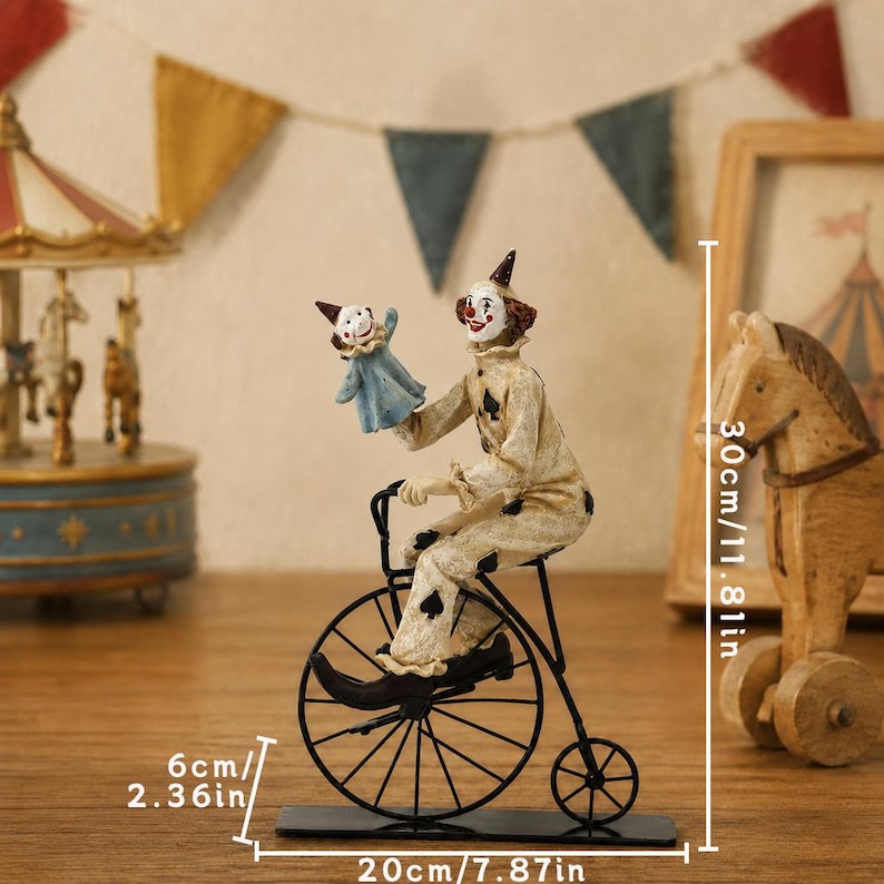 May include: A clown figurine riding a black metal penny-farthing bicycle and holding a small puppet. The clown wears a cream-colored suit with black spade patterns. The figurine measures 11.81 inches in height, 7.87 inches in width, and 2.36 inches in depth.