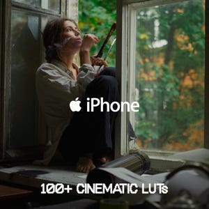 Puede incluir: Una persona sentada en una ventana sostiene materiales de arte. La imagen incluye el logotipo de Apple iPhone y el texto "100+ CINEMATIC LUTS". La escena está ambientada en una habitación con luz natural y vista de árboles afuera.