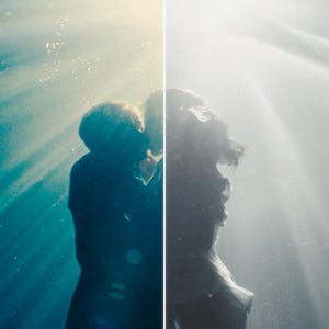 May include: A split-screen image shows two figures underwater, one in color and the other in grayscale. The figures are silhouetted against beams of light filtering down through the water, creating a dramatic and ethereal effect.