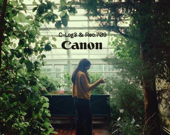 May include: A person wearing a mustard yellow long-sleeved shirt and dark pants stands in a greenhouse filled with lush green plants. The text C-Log3 & Rec.709 and Canon is printed in black in the center of the image against the glass structure.