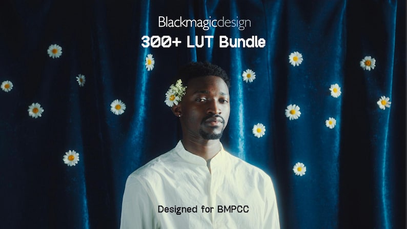 May include: A person wearing a white shirt with a high collar, adorned with flowers in their hair, stands before a dark blue curtain decorated with white daisies. The image features text that reads "Blackmagicdesign 300+ LUT Bundle" and "Designed for BMPCC."