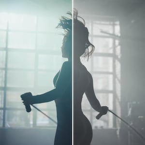 May include: Silhouette of a person jumping rope in a gym setting. The person is wearing athletic attire and holding the jump rope handles. The background features a window and a bright light source, creating a dramatic effect.