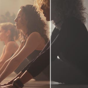 Puede incluir: Varias personas se muestran en una clase de yoga, realizando una postura con las manos en el suelo. La habitaci&oacute;n est&aacute; suavemente iluminada, con una atm&oacute;sfera brumosa. Las personas llevan ropa deportiva oscura.