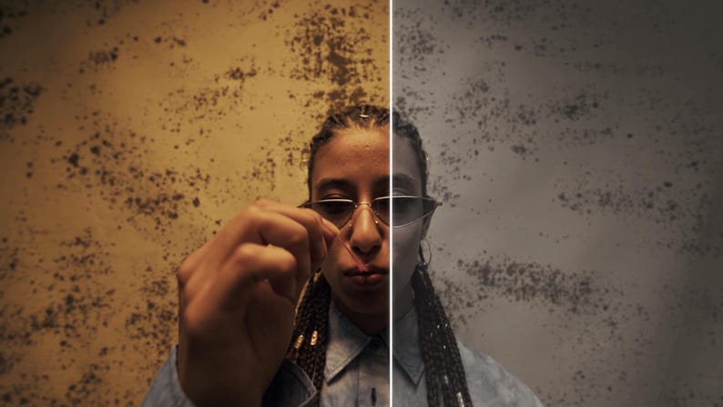 May include: A split-screen image featuring a person wearing sunglasses, with a textured wall background. The left side is warm-toned, while the right is cooler. The person is holding a small object, possibly a piece of jewelry.