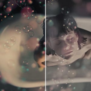 Puede incluir: Una persona en una ba&ntilde;era con los ojos cerrados, rodeada de burbujas flotantes. La imagen est&aacute; dividida, con el lado izquierdo desenfocado y el lado derecho enfocado. Las burbujas son iridiscentes, reflejando varios colores.