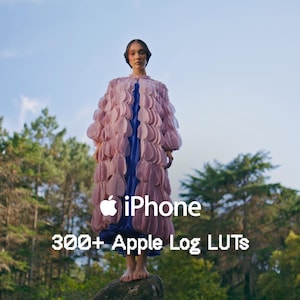 Pode incluir: Uma pessoa em pé sobre uma rocha em uma floresta, vestindo um casaco longo rosa e azul. A imagem inclui o logotipo da Apple iPhone e o texto "iPhone 300+ Apple Log LUTs."