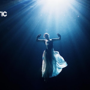 May include: A dramatic image featuring a person in a flowing white dress, arms outstretched, bathed in a bright light from above. The text "CINEMATIC Arctic Color" is visible against a dark blue backdrop.