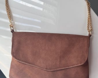 Handmade brown faux leather strap shoulder clutch with pink water- proof canvas interior and rose gold chain that is adjustable