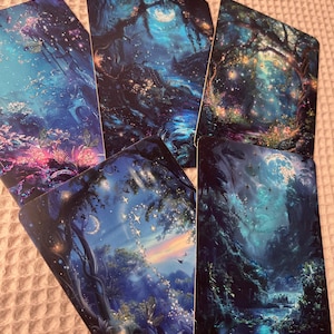 Könnte beinhalten: Eine Sammlung von Tarotkarten mit Fantasy-Kunst. Jede Karte zeigt eine andere Szene eines mondbeschienenen Waldes mit leuchtenden Lichtern, Schmetterlingen und einem Fluss. Die Farbpalette wird von Blau- und Grüntönen dominiert.
