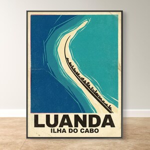May include: A framed vintage travel poster featuring a coastal scene with a road and the text "LUANDA ILHA DO CABO". The poster has a retro design with blue, teal, and beige tones, evoking a sense of nostalgia and travel.