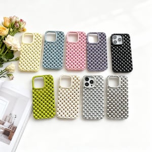 Puede incluir: Una colección de diez fundas de teléfono coloridas. Las fundas están disponibles en varios colores, incluyendo amarillo, azul, rosa, morado, negro, verde, blanco, plateado y marrón. Cada funda tiene un patrón texturizado similar a burbujas.