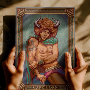 May include: A framed illustration of the Capricorn zodiac sign. The artwork features a muscular figure with curly red hair, horns, and a colorful cape. The image includes the word "CAPRICORN" at the bottom.