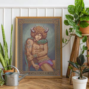 May include: A framed art print featuring a stylized illustration of a Capricorn zodiac sign. The artwork depicts a muscular figure with horns, wearing a green cape and purple briefs. The frame is a warm brown color, and the text "CAPRICORN" is visible at the bottom.