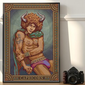May include: A framed art print featuring a stylized illustration of a Capricorn figure. The artwork depicts a person with curly brown hair, horns, and a cape, wearing purple shorts. The word "CAPRICORN" is at the bottom.