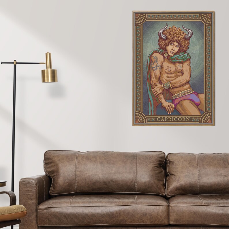 May include: A framed Capricorn zodiac art print. The artwork features a person with horns, wearing a green shawl and purple shorts. The print has a decorative border and the word "CAPRICORN" at the bottom.