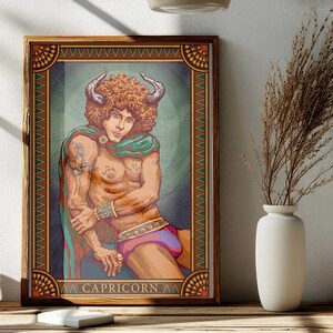 May include: A framed art print featuring a Capricorn zodiac illustration. The artwork depicts a person with curly red hair, horns, and a draped shawl. The image has a teal and brown color scheme, with the word "CAPRICORN" at the bottom.