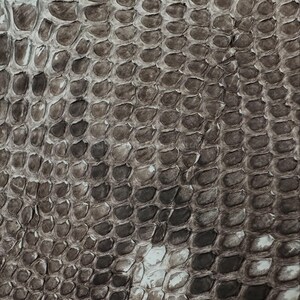 Pode incluir: Close-up de uma superfície texturizada com um padrão que se assemelha a escamas de cobra. As escamas são em tons de cinza, marrom e branco, criando uma aparência naturalista e detalhada. O padrão é consistente.