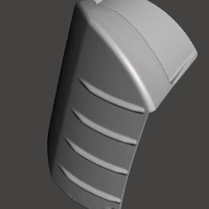 May include: A gray, curved plastic component with a series of horizontal grooves on one side. The object has a rounded top and a small hole at the bottom. The overall shape suggests a protective cover or housing.