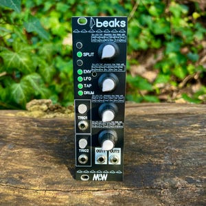 May include: A black electronic module with the text "beaks" and various control knobs and inputs. The module has labels such as "SPLIT", "ENV", "LFO", "TAP", and "DRUM". It also features "TRIG1", "TRIG2", "OUT1", and "OUT2" ports.