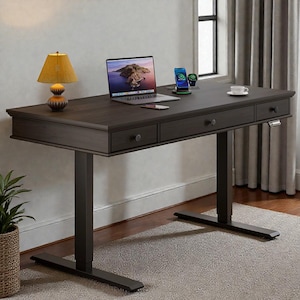 May include: A dark brown, rectangular, adjustable-height desk with three drawers. A laptop, phone, and lamp sit on the desk. The desk has a dark metal base and is on a light-colored rug.