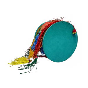Puede incluir: Un tambor turquesa con borlas coloridas. El tambor es redondo con una superficie plana y un lado redondeado. Las borlas son rojas, amarillas, azules y verdes. El tambor tiene una pequeña borla roja, amarilla y verde en el lateral.
