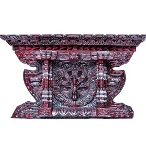 Könnte beinhalten: Ein geschnitzter Holzaltartisch mit roter und silberner Oberfläche. Der Tisch weist komplizierte Blumen- und geometrische Muster mit einem zentralen kreisförmigen Design auf. Der Tisch ist ein dekoratives Stück.