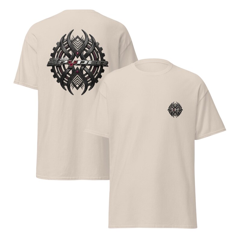 Peut inclure: Deux t-shirts beiges. L'un affiche un grand motif noir et gris au dos avec le texte "Spyder". L'autre t-shirt a un motif assorti plus petit sur le devant. Les graphiques ont un design en forme de roue dent&eacute;e.