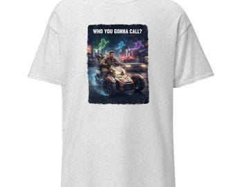 May include: Light gray t-shirt featuring a graphic of a person riding a three-wheeled vehicle in a city scene. The graphic includes the text "WHO YOU GONNA CALL?" in white letters.
