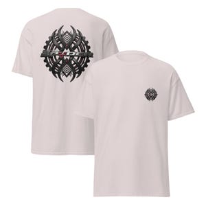 Peut inclure: Deux t-shirts rose clair. L'un a un grand motif noir et gris au dos avec le texte "SRYDER". L'autre a un motif assorti plus petit sur le devant gauche de la poitrine.