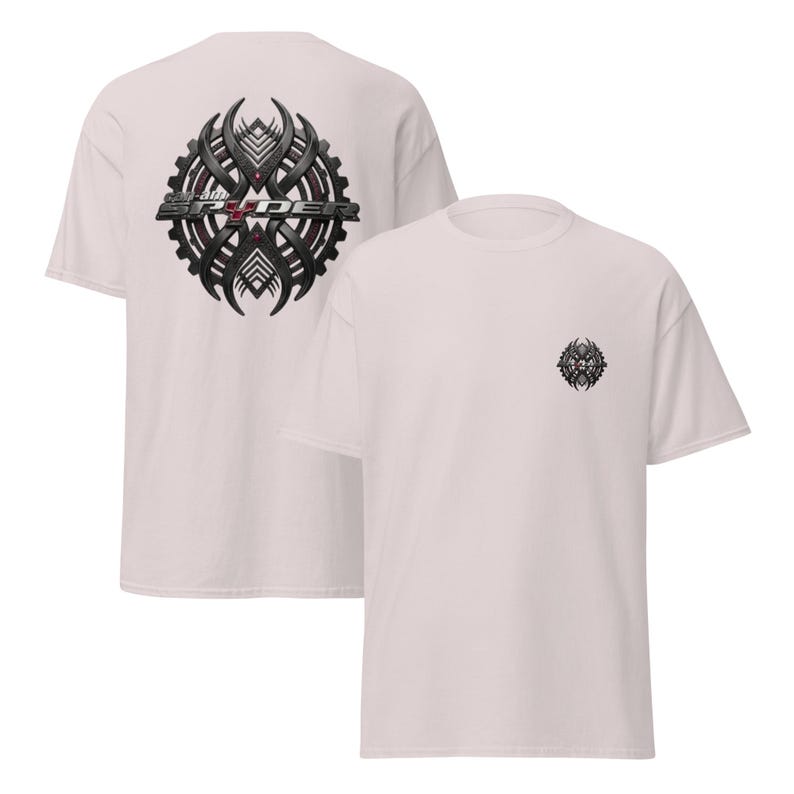Peut inclure: Deux t-shirts rose clair. L'un a un grand motif noir et gris au dos avec le texte "SRYDER". L'autre a un motif assorti plus petit sur le devant gauche de la poitrine.