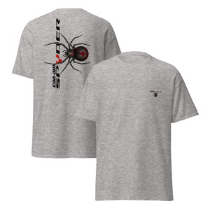 Pode incluir: Duas camisetas cinza mescladas. A parte de tr&aacute;s de uma camiseta apresenta um gr&aacute;fico de aranha preta e vermelha com o texto "can-am SPYDER". A outra camiseta tem um pequeno gr&aacute;fico de aranha e a palavra "spyder".
