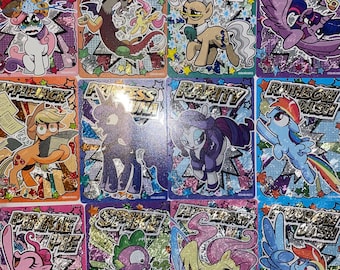 May include: A collection of colorful trading cards featuring cartoon ponies. Each card has a unique character illustration with a name banner. The cards have a glittery, holographic background with various colors and designs. The cards are rectangular and have a glossy finish.