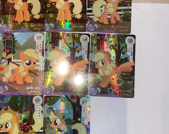 May include: A collection of trading cards featuring the character Applejack from My Little Pony. The cards showcase Applejack in various poses, with a focus on her signature orange and yellow color scheme. Each card has a holographic background.