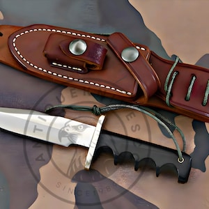 Könnte beinhalten: Ein Jagdmesser mit polierter Stahlklinge und schwarzem Griff, neben einer braunen Lederscheide. Die Scheide hat eine Gürtelschlaufe und einen Druckknopfverschluss. Die Messerklinge hat ein geätztes Adlerdesign. Messer und Scheide liegen auf einem Tarnhintergrund.