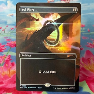 May include: A Sol Ring trading card featuring a dark, metallic ring floating in a fiery landscape with a dragon silhouette. The card text reads Sol Ring, Artifact, and the ability symbol for adding two colorless mana. It includes the artist name Brandon L Hunt.