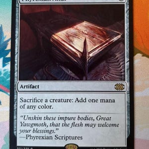 Puede incluir: Una carta coleccionable Phyrexian Altar con una ilustración de un altar metálico oscuro. El texto dice: Phyrexian Altar, 3, Artifact, Sacrifice a creature: Add one mana of any color. Unskin these impure bodies, Great Yawgmoth, that the flesh may welcome your blessings. Phyrexian Scriptures, 311/331 R, 2X2 EN, Yigit Koroglu, 2022 Proxies of the Coast.