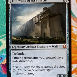 Op de afbeelding: Een Magic: The Gathering-kaart getiteld "The Walls of Ba Sing Se". De kaart toont een illustratie van een grote, imposante muur. De kaarttekst beschrijft het als een Legendary Artifact Creature - Wall met de Defender-vaardigheid.