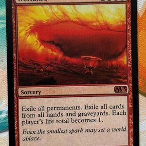 Op de afbeelding: Een Magic: The Gathering ruilkaart getiteld Worldfire, met een rode rand en een illustratie van een enorme vuurexplosie. De kaarttekst luidt: Exile all permanents. Exile all cards from all hands and graveyards. Each player's life total becomes 1.