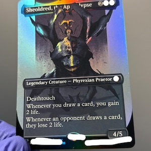 Puede incluir: Una carta coleccionable holográfica de Sheoldred, the Apocalypse con la ilustración de una criatura oscura de múltiples extremidades. La carta muestra el texto Legendary Creature - Phyrexian Praetor, Deathtouch y reglas sobre robar cartas.
