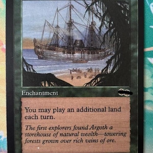 Könnte beinhalten: Eine Magic: The Gathering Sammelkarte mit dem Titel Exploration, die ein großes Segelschiff vor einem Sandstrand mit Figuren am Ufer zeigt. Der Kartentext lautet: You may play an additional land each turn.